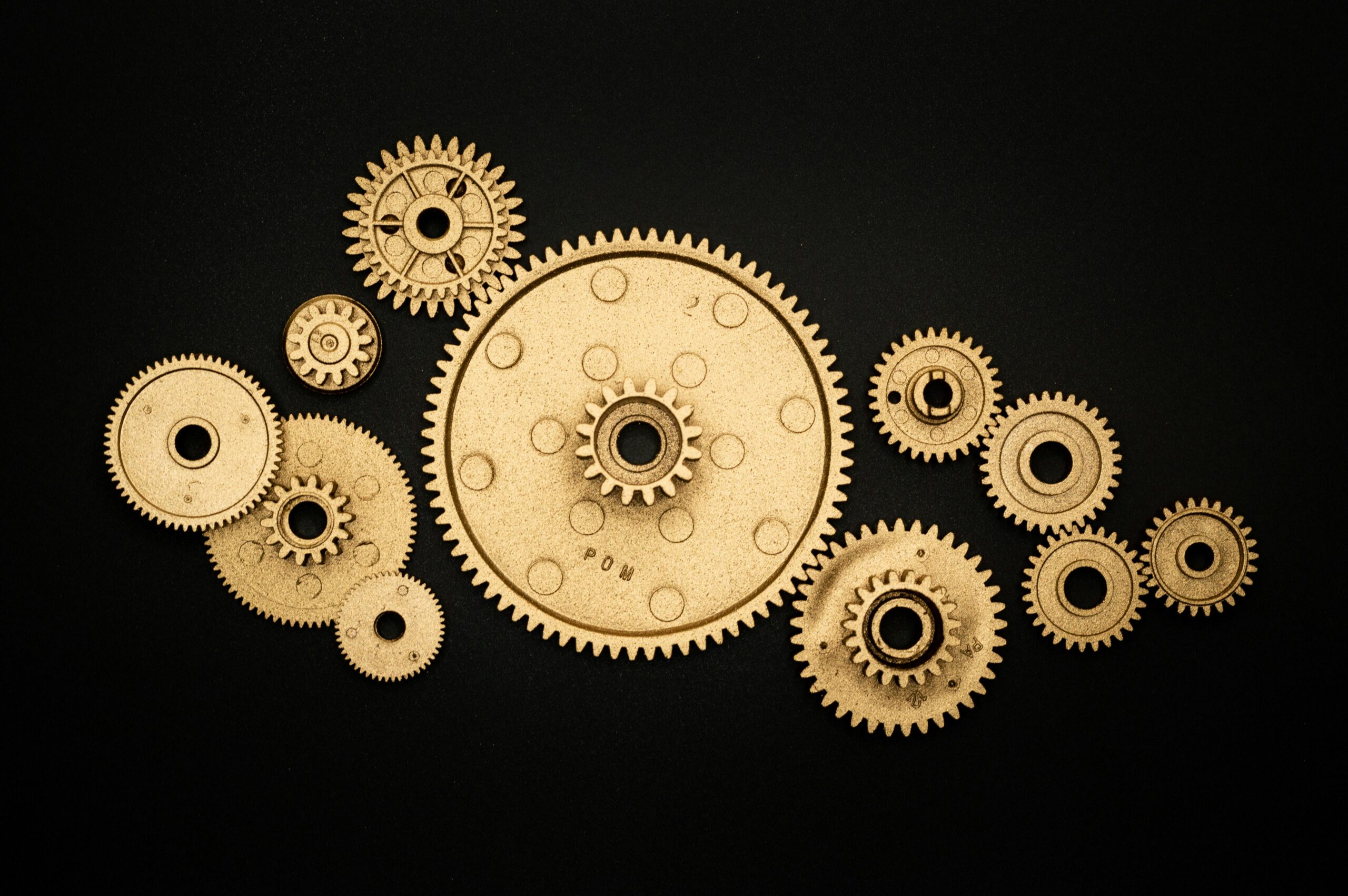 Golden gears on a black background representing industry and cooperation.